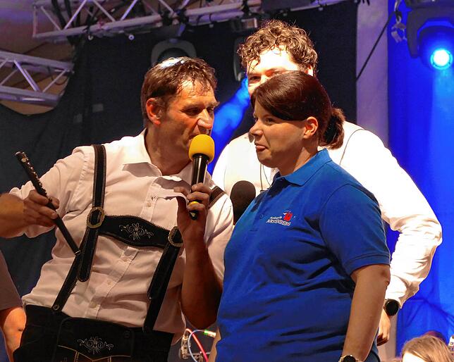 Moderator Uli Ocker (links) animiert Musikkapellen-Vorsitzende Melanie Vollmer zum Spiel auf der Piccolo-Flöte, sich noch etwas ...