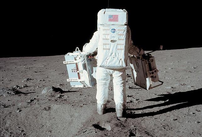 Zwar hüpften die Astronauten auch. Aber sie hatten viel zu tun. Hier trägt Edwin Aldrin zwei Instrumente.