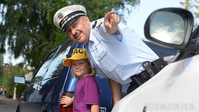 Der Stuttgarter Polizeihauptkommissar Hans Satorius zeigt einem Kind, wie man Gefahren auf dem Schulweg sicher meistern kann. In vielen ...