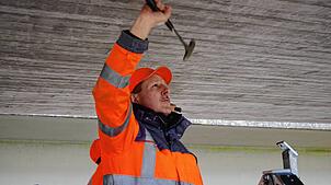 Klaus Blum sucht mit dem Hammer nach Hohlstellen.