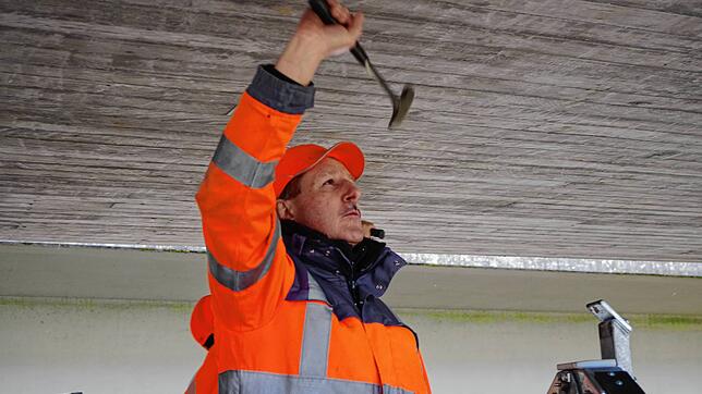 Klaus Blum sucht mit dem Hammer nach Hohlstellen.
