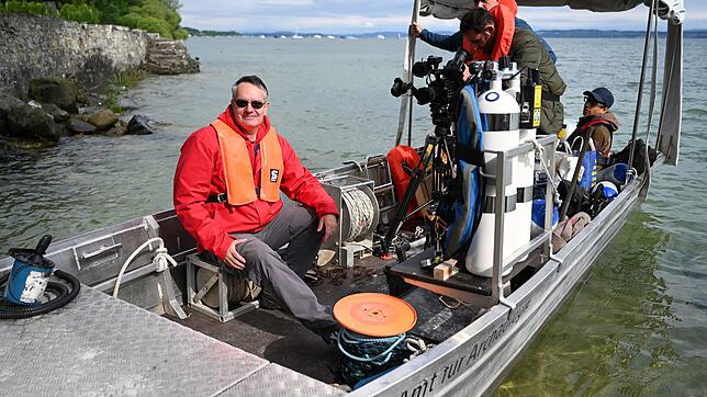Archäologe Urs Leuzinger (l) vom Amt für Archäologie in Frauenfeld, sitzt auf einem Boot, um unmittelbar danach auf den Bodensee ...