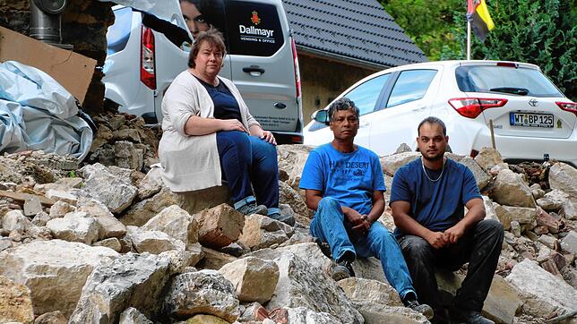 Elisabeth, Berty und Marius Perera auf den Trümmern der eingerissenen Gebäudehälfte.