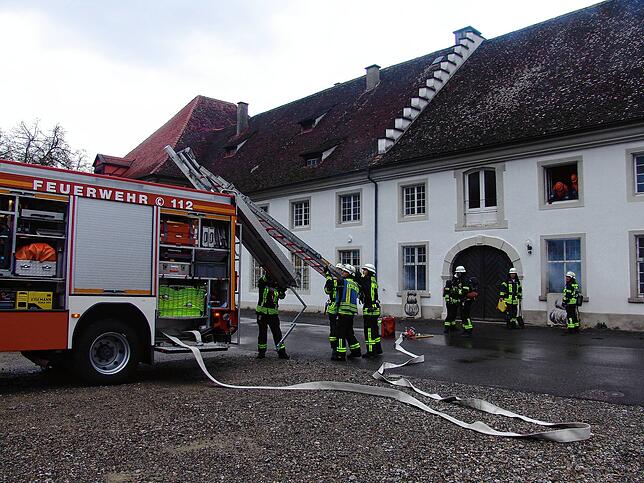 Die Feuerwehrleute bauen die tragbare Leiter auf, um die Handwerker aus dem Obergeschoss des Marstallgebäudes zu retten. Aufgrund der ...
