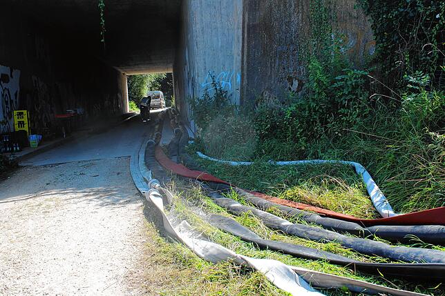 Unter der Autobahnbrücke sind diverse Schläuche verlegt worden. Der eigentliche Einsatzort liegt hinter der Brücke.