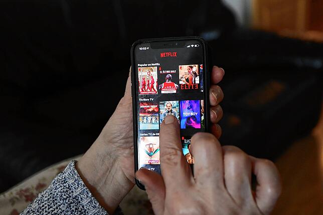 Eine Person schaut sich das Angebot von Netflix auf ihrem Handy an.