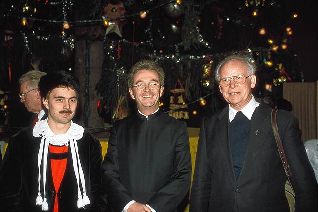 Matthias Vogt (von links) von der Trachtenvereinigung Alt-Hotzenwald, Pfarrer Peter Berg und dessen Vorgänger Peter Betz vor dem Christbaum.