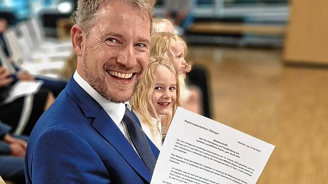 Luca Wilhelm Prayon hält die Niederschrift seiner Vereidigung als Landrat in Händen. Neben ihm freut sich sein Sohn Kaspar.