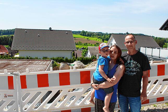 Philip, Janine und Christian Geller an ihrer Baustelle. Ob es mit dem Bau weitergeht, hängt an einem weiteren Kredit ihrer Bank.