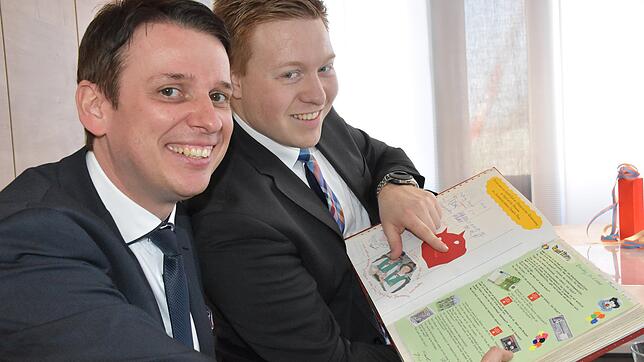 Stefan Haug (von links), Marketing, und Stephan Hans, Kundenberater, bestaunen die alten Sparkassen-Einträge im Narrenbuch des ...