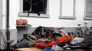 Vor dem Haus liegen verkohlte Gegenstände. Bild: Sebastian Kurtenacker