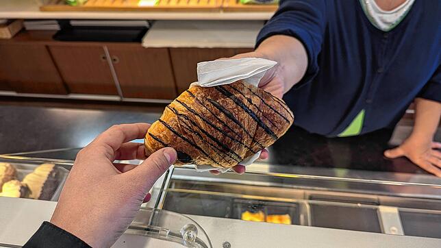 In der Bäckerei Ainser wird ein Schokocroissant überreicht. Wo können die Stockacher während der Feiertage Brezeln, Croissants und Co. ...