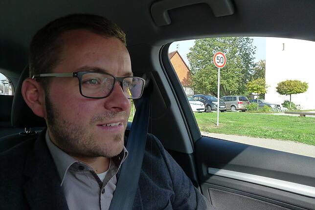 Bei der Probefahrt im neuen Hybrid-Dienstfahrzeug der Gemeindeverwaltung fährt Bürgermeister Fabian Meschenmoser an der Kirche in ...