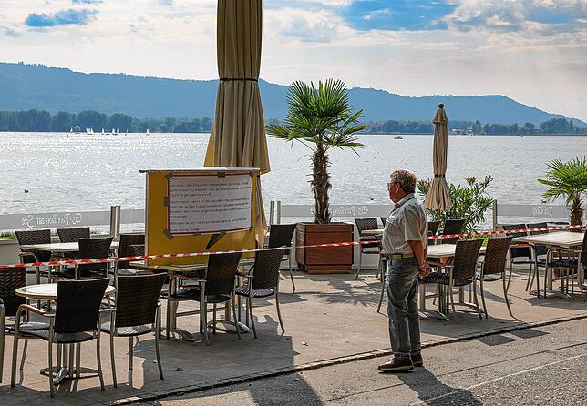 Trotz bestem Wetter keine Außengastronomie: Ein Passant liest die Informationstafeln, mit der der Betreiber an der Mole seinen Protest ...