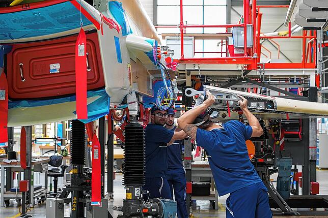 Airbus-Mitarbeiter montieren eine linke Tragfläche an den Rumpf. Wenn die Produktion voll hochgefahren ist, sollen jährlich zehn der ...