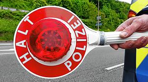 Ein Polizist hält eine Kelle, um das Anhalten zu signalisieren (Symbolbild). Dieser Aufforderung kam ein Autofahrer nicht nach und ...
