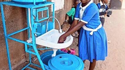 Eine Schülerin der St. Peter&lsquo;s Lower Basic School in Gambia demonstriert, wie man die vom Jobclub VS gesponserten Handwaschstation ...