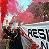 Menschen halten bei einer Pro-Palästina-Demonstration Banner und Flaggen und lassen bunten Rauch aufsteigen auf einer Straße in der ...
