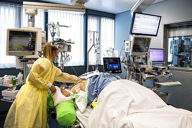 Eine Pflegerin im Universitätsspital Bern der Insel Gruppe kümmert sich auf der Intensivstation um einen Corona-Patienten.