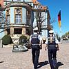 Dienstag, kurz nach der Mittagszeit. Eine Polizeistreife patroulliert vor dem blauen Rathaus.