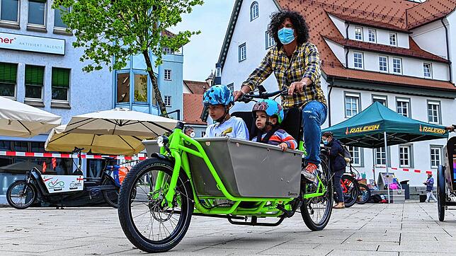 Afaoui Imed probiert auf dem Schwenninger Marktplatz verschiedene E-Lastenräder aus. Seine Kinder Amir und Sami sind begeistert.