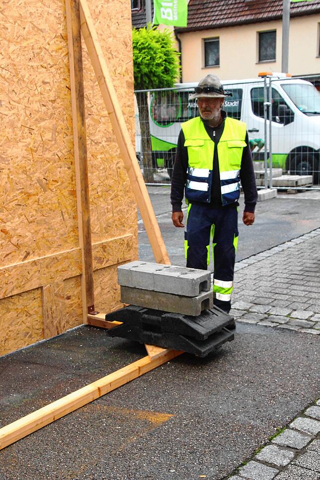 Damit die vom Bauhof aufgestellte Malwand für das 3D-Bild auf dem Marktplatz nicht vom Wind umgeworfen wird, wird sie an mehreren ...