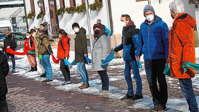 Fast 200 Teilnehmer zählt die Menschenkette, die mit Hilfe von bunten Bändern geknüpft wird. Bild: Stefan Heimpel