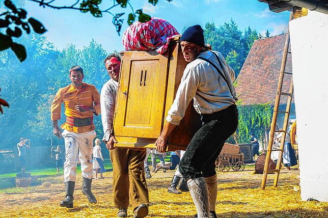 Die Einwohner von St. Georgen bringen ihr Hab und Gut in Sicherheit. Hier schleppen Klaus Lauble und Ferdinand Haas eine Kommode durch ...