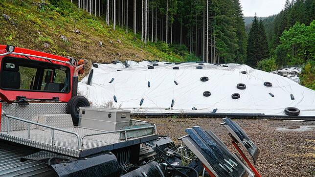 Der Pistenbully steht bereit um den Schnee des Schwarzwaldgletschers, der noch unter der Folie wartet, auf die Schanze und den Auslauf ...