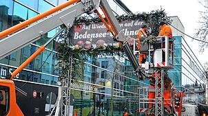 Mitarbeiter des Bauhofs dekorieren die Zugänge zur Bodensee-Weihnacht. Der Weihnachtsmarkt am See in Friedrichshafen wird am Donnerstag ...