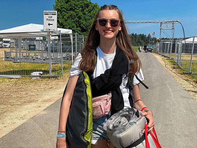 Mathilda läuft voll bepackt in Richtung Parkplatz. Später geht sie wieder aufs Festivalgelände.