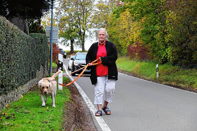 Anwohnerin Lioba Kästle mit ihrem Hund an der betroffenen Straße. Sie berichtet von Lastwagen, die bereits ab 5 Uhr morgens fuhren.