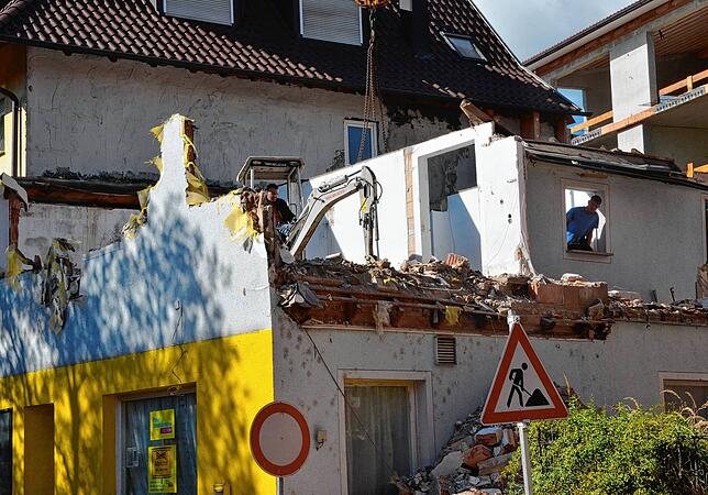 Auf der Zwischendecke des gelben Hauses ist am Dienstag ein Minibagger zugange. Wegen der schlechten Bausubstanz müssen größere Teile ...