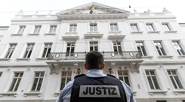 Ein Justizbeamter steht vor dem Landgericht.