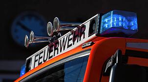 Ein Feuerwehrfahrzeug mit eingeschaltetem Blaulicht (Symbolbild). Der Brand in einer Dachgeschosswohnung in Küssaberg löste einen ...