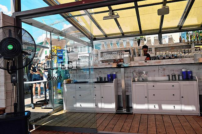 Hinter der großen Bar im Strandhaus-Stil werden Cocktails gemischt.