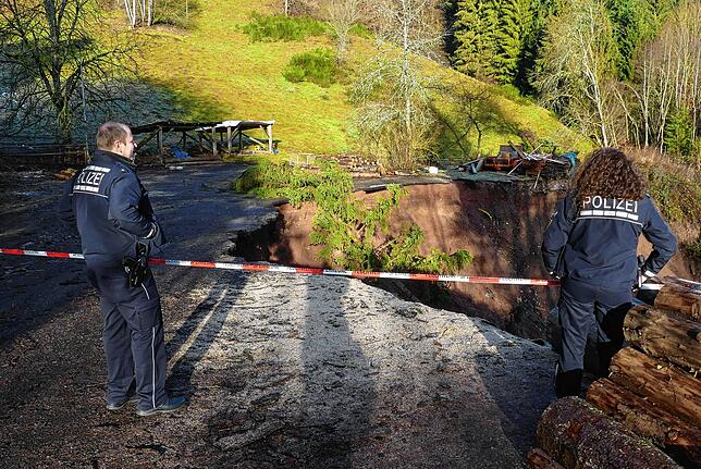 Zwei Polizeibeamte sperren die Abbruchkante des Hangrutsches am 15. Januar 2019 ab.