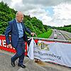 Verkehrsminister Winfried Hermann enthüllt auf der Autobahnbrücke bei Geisingen eines der Motive.
