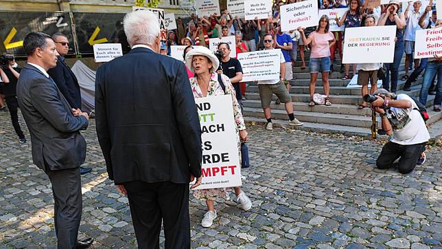 Vor der Rede in der Konstanzer Christuskirche: Ministerpräsident Winfried Kretschmann geht auf die Demonstranten zu, die gegen die ...
