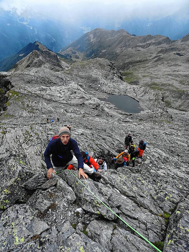 Andreas Steidle klettert hochkonzentriert entlang des Seils, das Hans Kammerlander vorab befestigt hat.