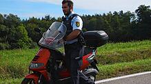 Ein Polizist schiebt nach einem Unfall an der Ausfahrt Nußdorf ein Motorrad von der Straße.