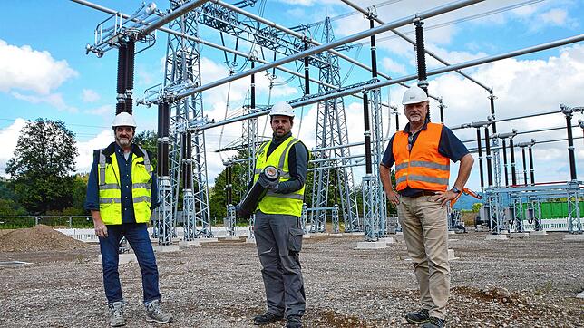 Hubert Geiger (von links), Raphael Maise und Henning Meier. Raphael Maise zeigt den Querschnitt einer 110-kV-Leitung.