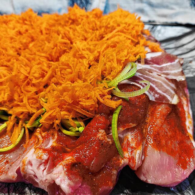Speck, Lauch und Karotten sind auf dem Fleisch geschichtet, nun fehlt nur noch der Brätkern.