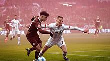 St. Paulis Noah Weißhaupt (l) und Freiburgs Philipp Lienhart im Kampf um den Ball.