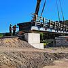 27 Meter ist das längste Element der Behelfsbrücke lang. Es wird in Präzisionsarbeit auf die Mittelstütze und das Widerlager abgesenkt.