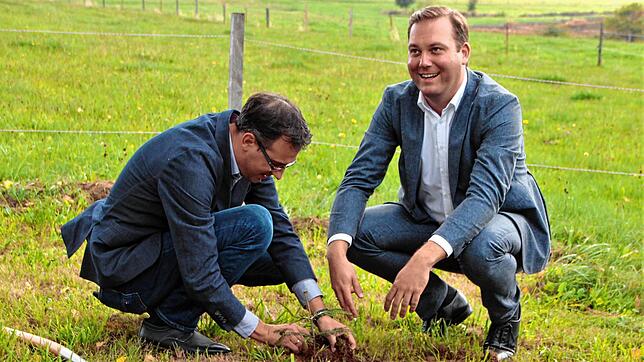 Christian Dröse (links) und Felix Schreiner pflanzen einen Weißtannensetzling, den Landwirtschaftsministerin Julia Klöckner dem ...