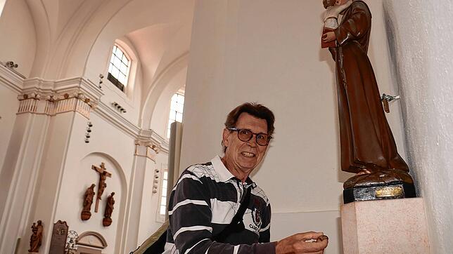 Johannes Förschner, Urlauber aus Wörth, steckt in der Stadtkirche St. Johann dem Heiligen Antonius eine Münze zu. Das Spendenaufkommen ...