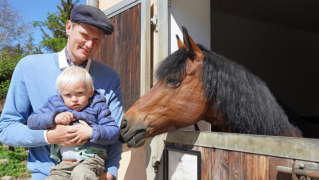 Na, wer seid ihr denn? Laurenz Schmidt mit seinem zweijährigen Sohn Raphael, der keine Berührunsgängste mit Pferden hat, aber der Kamera ...