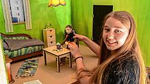 Lilith Jörg am selbst gebauten Filmset, das die Wohnstube des Protagonisten zeigt. Jede minimale Veränderung muss von Hand ausgeführt ...