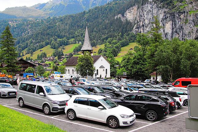 Voller Parkplatz vor der Kirche in Lauterbrunnen.